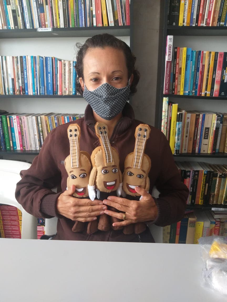 Participante do projeto com os bonecos da Turma do Torkynho confeccionados por ela